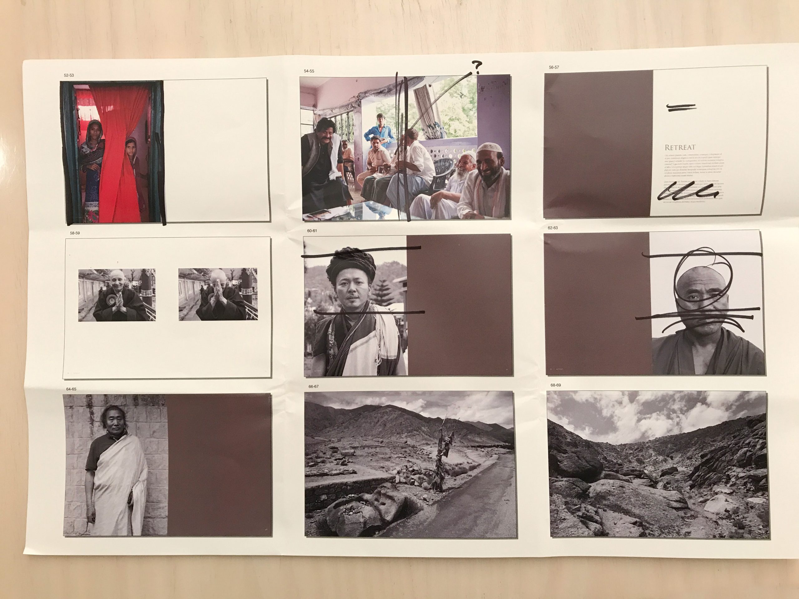 Behind-the-scenes photo showing book design process with printed proofs and layout materials