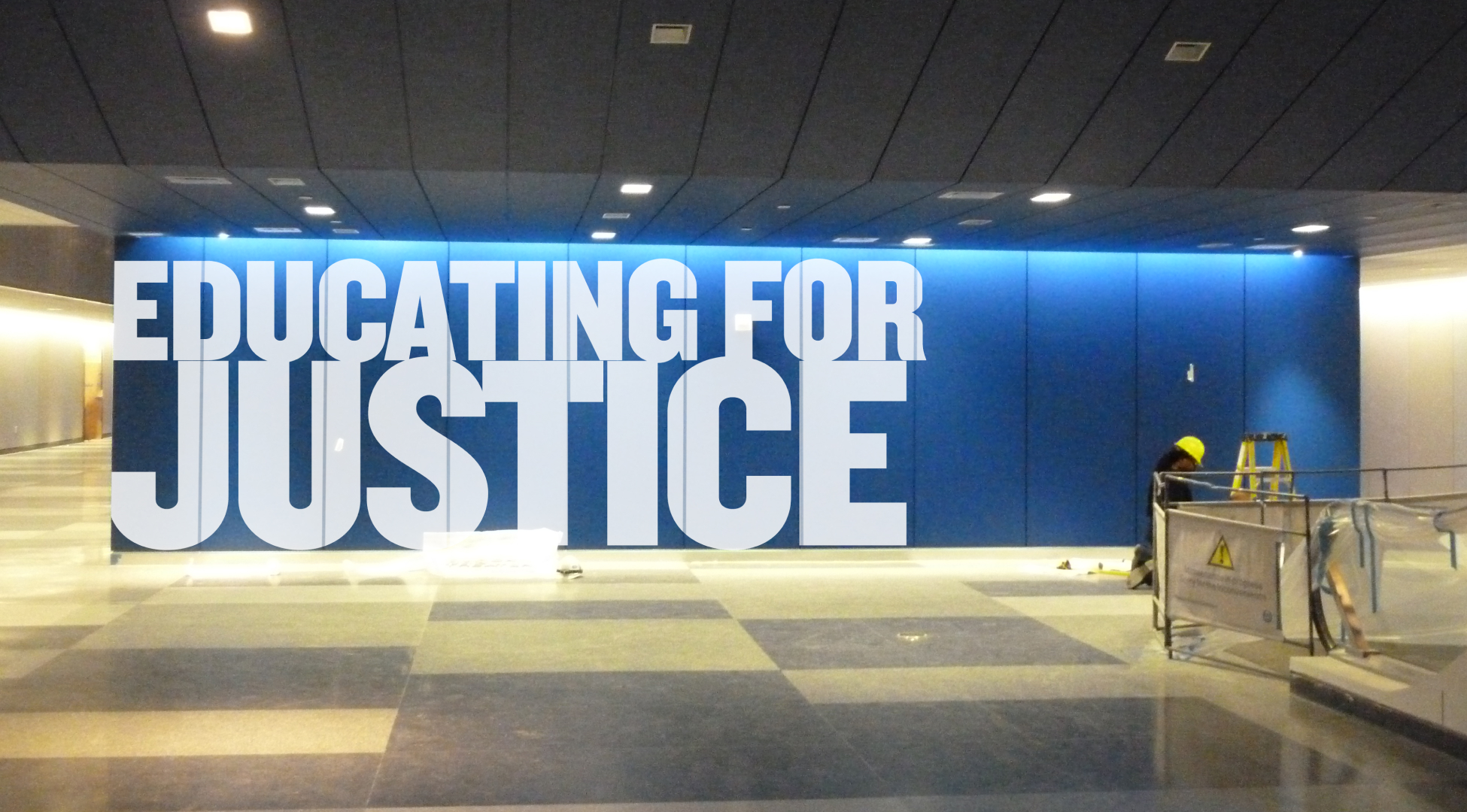 Interior wall featuring large-scale 'Educating for Justice' messaging on blue background