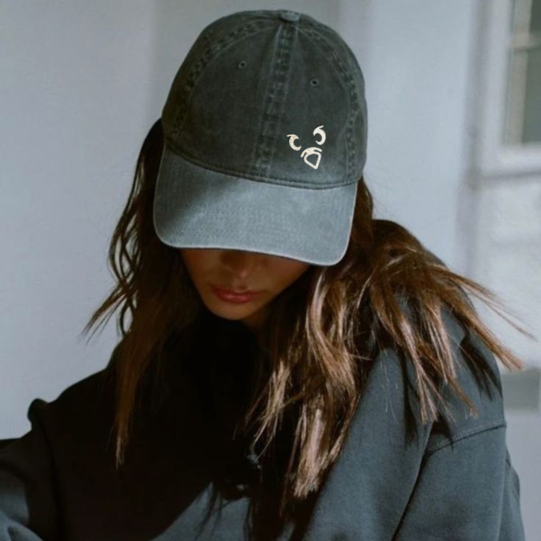 Woman wearing baseball cap with Fat Pigeon Social logo, demonstrating brand merchandise and lifestyle application