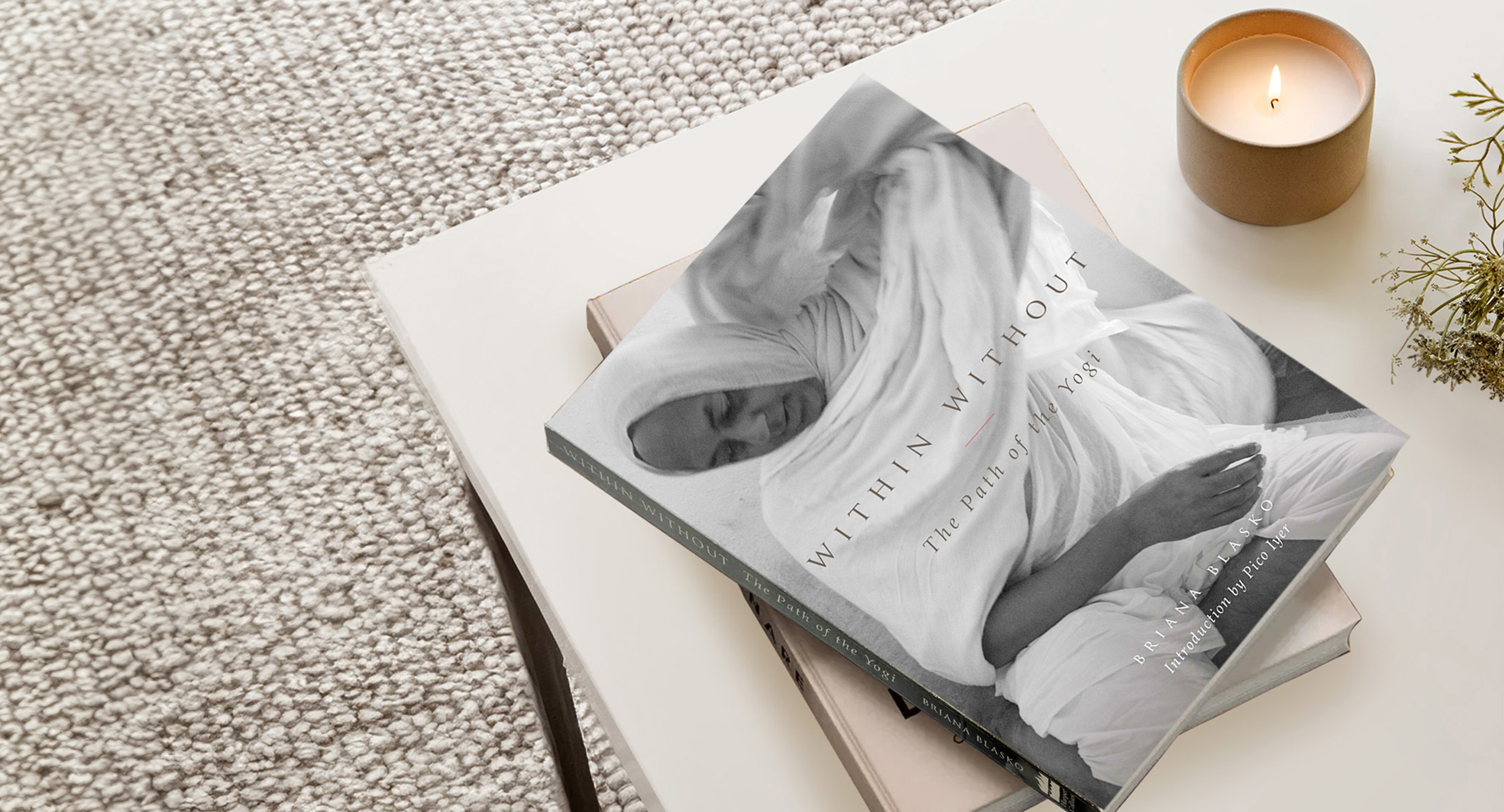 Coffee table with the book 'Within Without: The Path of The Yogi' sitting on top of a stack of books